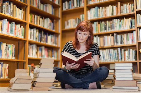 Student in pile of books in library Stock Photo - Premium Royalty-Free, Code: 649-05801359