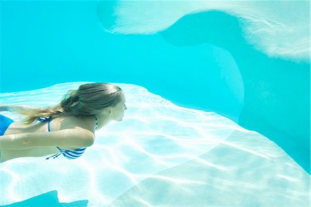 Woman in bikini swimming in pool Stock Photo - Premium Royalty-Free, Code: 649-05819766