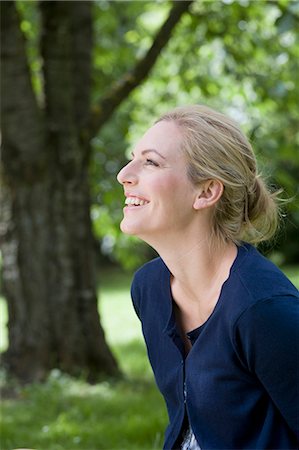 simsearch:649-05819818,k - Smiling woman sitting outdoors Stock Photo - Premium Royalty-Free, Code: 649-05819819