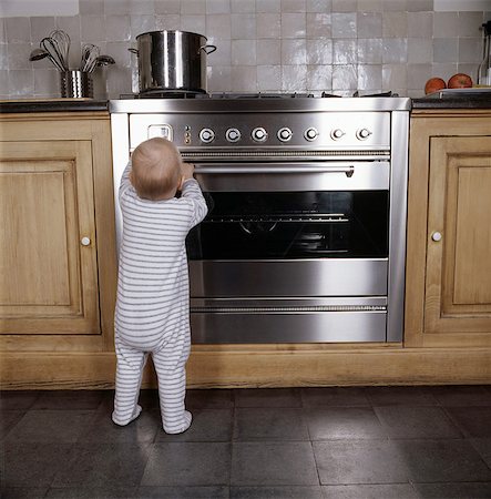 Infant standing by oven in kitchen Stock Photo - Premium Royalty-Free, Code: 649-05820059