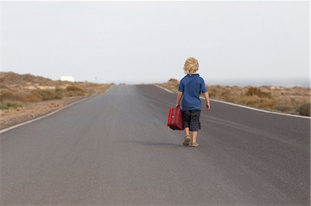 fuerteventura - Boy carrying suitcase on rural road Stock Photo - Premium Royalty-Free, Code: 649-05820320