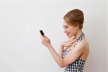 Smiling woman using cell phone Stock Photo - Premium Royalty-Free, Code: 649-05820870