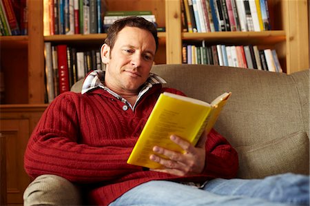 Man reading book on sofa Stock Photo - Premium Royalty-Free, Code: 649-05821022