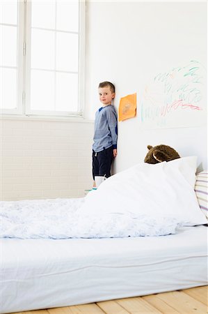 Boy with drawings on bedroom wall Stock Photo - Premium Royalty-Free, Code: 649-05949796