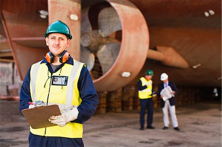 shipping (moving goods) - Worker carrying clipboard on dry dock Stock Photo - Premium Royalty-Free, Code: 649-05950055