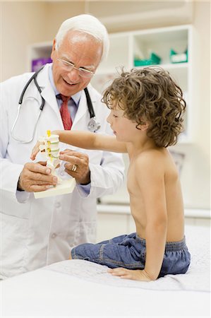 doctor talking with older patient - Doctor showing boy model in office Stock Photo - Premium Royalty-Free, Code: 649-05950089