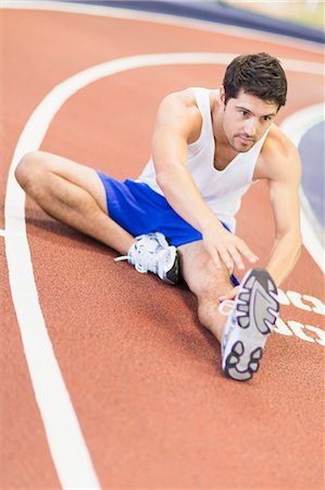 stretch - Man stretching on indoor track in gym Stock Photo - Premium Royalty-Free, Code: 649-05950183