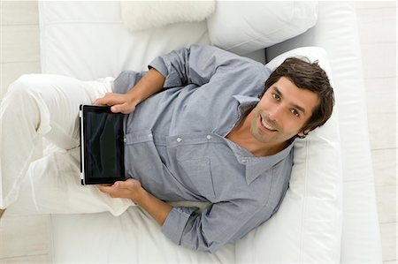 simsearch:649-05648787,k - Man using tablet computer on sofa Stock Photo - Premium Royalty-Free, Code: 649-06000353