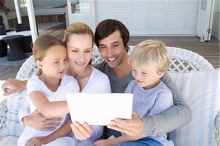 daughter sitting on dad lap - Family using tablet computer together Stock Photo - Premium Royalty-Free, Code: 649-06000369