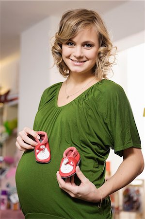 portrait of pregnant woman - Pregnant woman buying baby shoes Stock Photo - Premium Royalty-Free, Code: 649-06000414