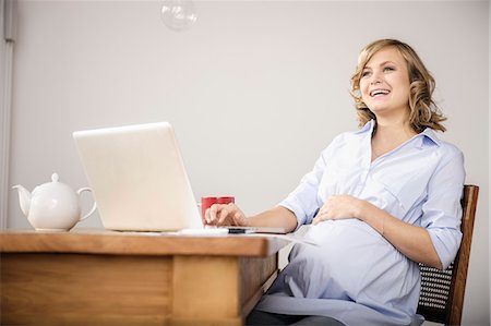 photograph of pregnant women - Pregnant woman using laptop in kitchen Foto de stock - Sin royalties Premium, Código: 649-06000418