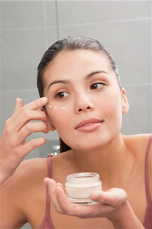 Woman applying moisturizer to face Stock Photo - Premium Royalty-Free, Code: 649-06000653