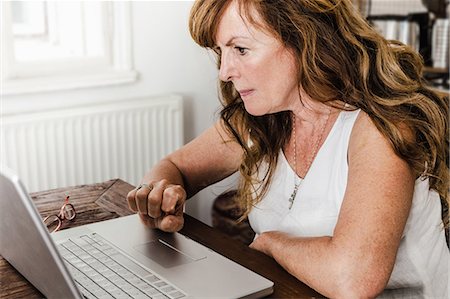 red hair senior woman - Older woman using laptop in kitchen Stock Photo - Premium Royalty-Free, Code: 649-06000707