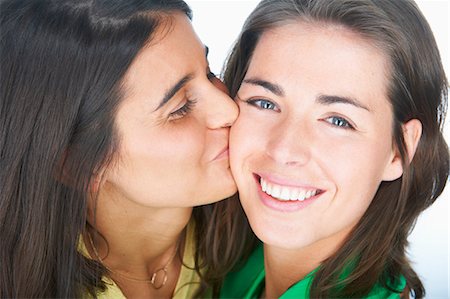 simsearch:400-06204561,k - Woman kissing smiling friends cheek Stock Photo - Premium Royalty-Free, Code: 649-06000764