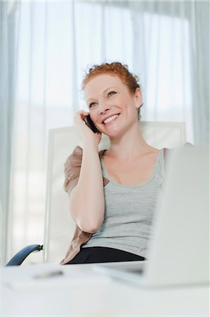red haired businesswomen - Businesswoman talking on phone at desk Stock Photo - Premium Royalty-Free, Code: 649-06000903