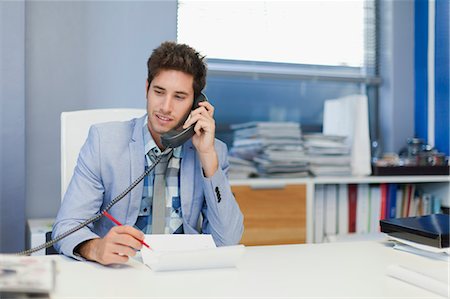 pupitre - Businessman talking on phone at desk Foto de stock - Sin royalties Premium, Código: 649-06000943