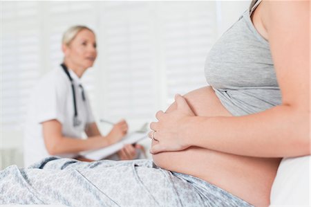 doctor examining pregnant belly - Doctor talking to pregnant woman Stock Photo - Premium Royalty-Free, Code: 649-06001078