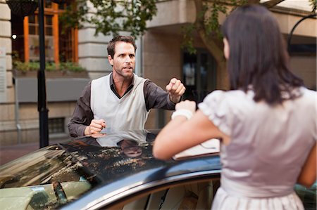 embarrassed women - Couple arguing over sports car Stock Photo - Premium Royalty-Free, Code: 649-06040248