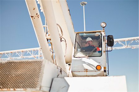 Worker operating crane at oil refinery Stock Photo - Premium Royalty-Free, Code: 649-06040376