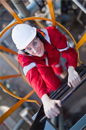 Worker climbing ladder at oil refinery Stock Photo - Premium Royalty-Free, Code: 649-06040486
