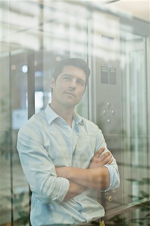 Businessman riding glass elevator Stock Photo - Premium Royalty-Free, Code: 649-06040672