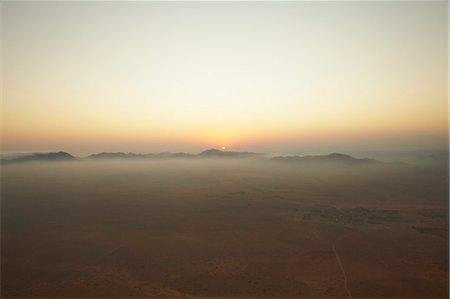 Sun setting over foggy landscape Stock Photo - Premium Royalty-Free, Code: 649-06040992