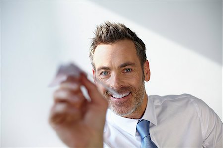 Businessman playing with paper airplane Stock Photo - Premium Royalty-Free, Code: 649-06041146
