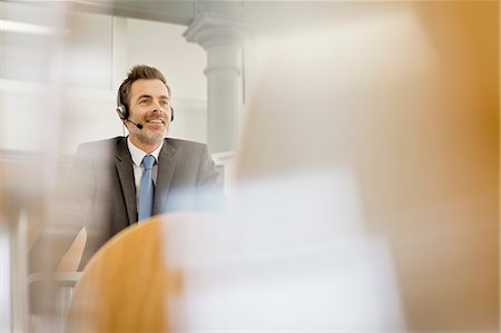 simsearch:846-05648290,k - Businessman wearing headset at podium Stock Photo - Premium Royalty-Free, Code: 649-06041284