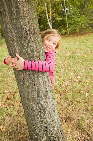 simsearch:649-06041783,k - Smiling girl hugging tree outdoors Stock Photo - Premium Royalty-Free, Code: 649-06041785