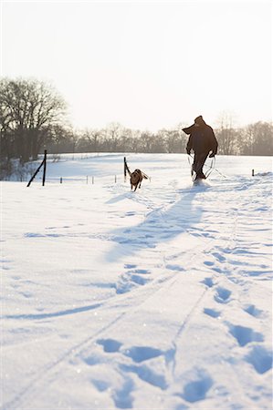 people walking in the distance - Man walking dog in snowy field Stock Photo - Premium Royalty-Free, Code: 649-06041843