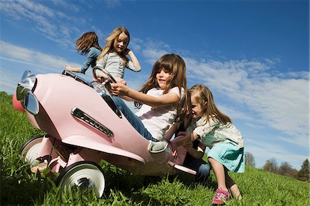 Girls driving toy airplane outdoors Stock Photo - Premium Royalty-Free, Code: 649-06112598