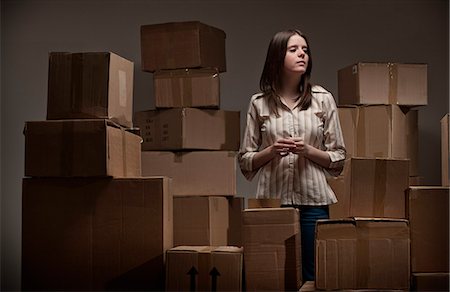 Teenage girl in pile of cardboard boxes Stock Photo - Premium Royalty-Free, Code: 649-06112644