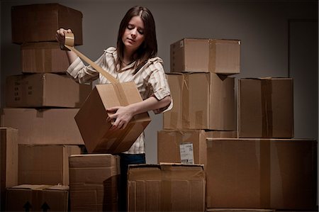 Teenage girl taping up cardboard boxes Stock Photo - Premium Royalty-Free, Code: 649-06112645