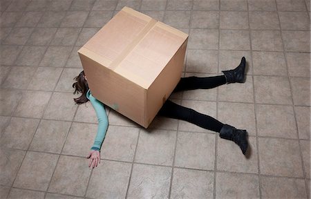 Teenage girl lying under cardboard box Foto de stock - Sin royalties Premium, Código: 649-06112660