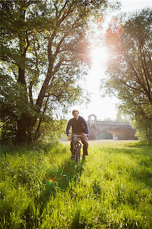 Man riding bicycle in field Stock Photo - Premium Royalty-Free, Code: 649-06112676