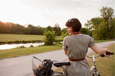 Woman walking bicycle on rural road Stock Photo - Premium Royalty-Free, Code: 649-06112671