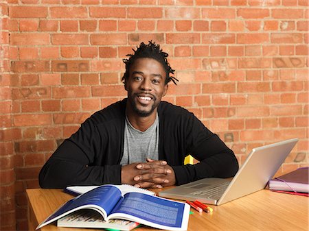 Smiling man studying with laptop Stock Photo - Premium Royalty-Free, Code: 649-06112712