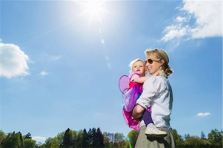 family outdoors blue sky - Mother carrying toddler girl outdoors Stock Photo - Premium Royalty-Free, Code: 649-06112818