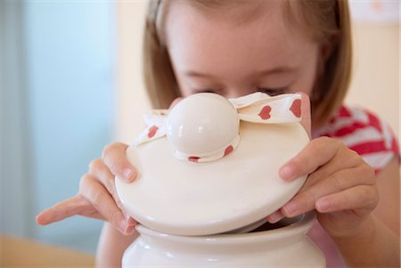 food jars - Girl opening cookie jar in kitchen Stock Photo - Premium Royalty-Free, Code: 649-06112913