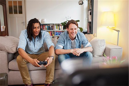 Men playing video games in living room Stock Photo - Premium Royalty-Free, Code: 649-06112944