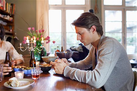 Man using cell phone at dinner table Stock Photo - Premium Royalty-Free, Code: 649-06112966
