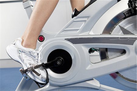 Woman pedaling stationery bicycle Foto de stock - Sin royalties Premium, Código: 649-06113440