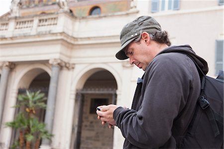 Man using cell phone on city street Stock Photo - Premium Royalty-Free, Code: 649-06113623