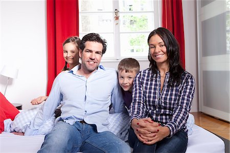 simsearch:649-03770663,k - Family smiling together on bed Stock Photo - Premium Royalty-Free, Code: 649-06113828