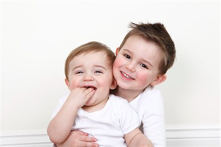 picture of a baby boy smiling - Smiling boy holding baby brother Stock Photo - Premium Royalty-Free, Code: 649-06164433
