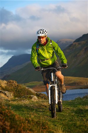 people enjoying in the lake - Mountain biker on grassy hillside Stock Photo - Premium Royalty-Free, Code: 649-06165069