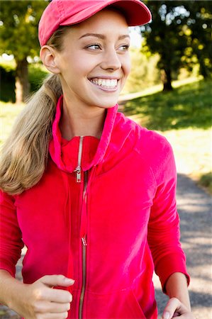 sideways glance - Smiling woman jogging outdoors Stock Photo - Premium Royalty-Free, Code: 649-06304851