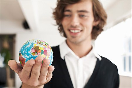 Teenage boy holding miniature globe Stock Photo - Premium Royalty-Free, Code: 649-06305261