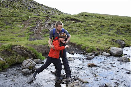 Father and daughter crossing stream Stock Photo - Premium Royalty-Free, Code: 649-06305452