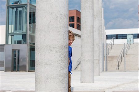 school building - Boy peering out from behind column Stock Photo - Premium Royalty-Free, Code: 649-06305521